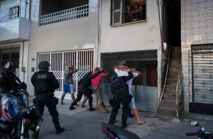 Police officers searching participants of a demonstration in Fortaleza, Brazil.
