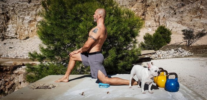 a man stretching next to a dog