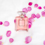 rosa parfymflaska med rosblad runtom