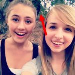 Dos chicas tomándose una selfi y algo oscuro identificable está detrás de ellas