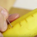 man sticks a needle into a banana