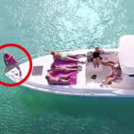 drone captures man with women on a boat