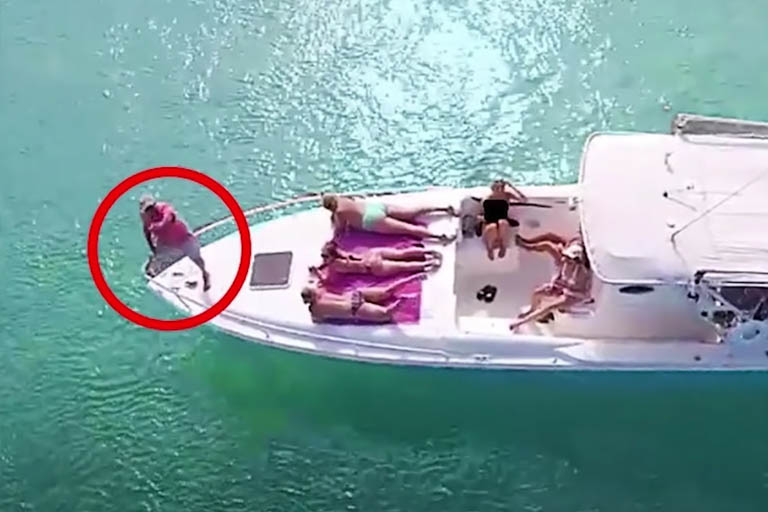 drone captures man with women on a boat